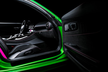 Fototapeta na wymiar Modern Luxury sport car inside. Interior of prestige car. Black Leather seats with pink stitching. Black perforated leather. Modern car interior details.