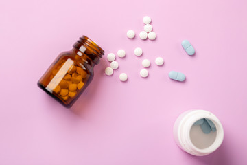 Different medications. Various pill bottles. One-color backdrop.