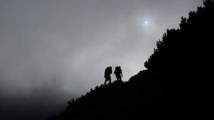 Hikers climbing towards the mist