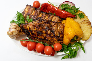 Grilled pork ribs with potatoes, peppers, potatoes, onions and sprinkled with parsley