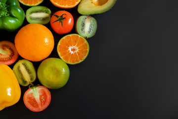 Many fruits and vegetables placed on the black background.

Plenty of vegetables and fruits and there's space to put text.