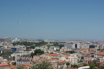 plane flying over Lisbon skyline