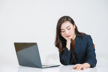 Stressed asian woman sitting at office desk with laptop 