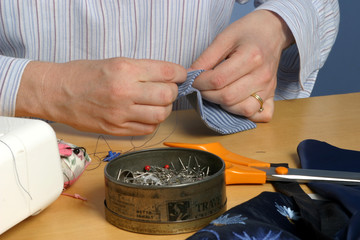 Female hands sewing a piece of cloth