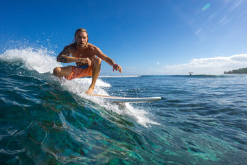 muscular surfer with long white hair riding on big waves on the Indian Ocean island of Mauritius