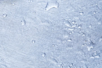 liquid droplets on silver colored metal surface. background backdrop. soft focus.