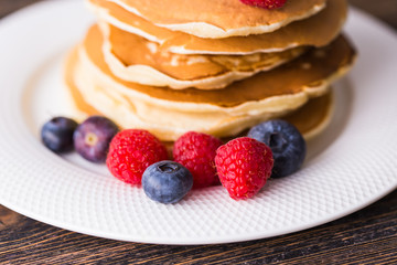 Close-up delicious pancakes with fresh blueberries and raspberries.