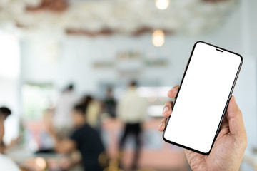 Mockup image of hand holding smartphone in coffee shop.