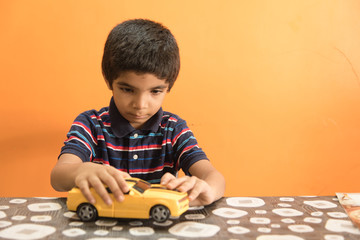 Young little boy playing with toy car