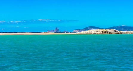 Formentera, Balearic Islands / Spain. Ses Illetes beach seen from a boat with the island of Es Vedrà in the distance