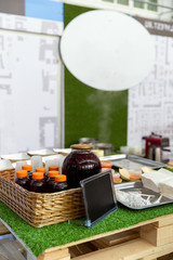 Glass jar with tasty fruit drink and black plate for text