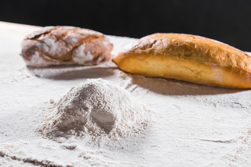Fresh bread on table close-up in flour placer. Fresh bread on the kitchen table. The healthy eating...