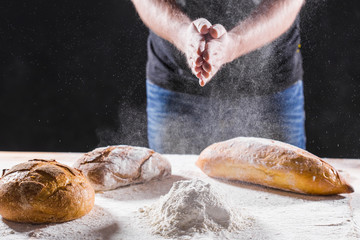 Baker cooking bread. Man slaps flour. Food concept.