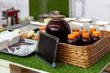 Glass jar with tasty fruit drink and black plate for text