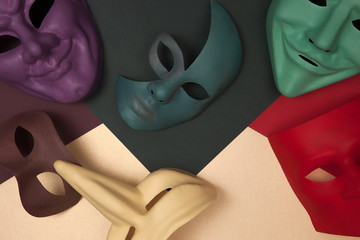 Multi-colored venetian masks of different shapes and types on green and pink gold backgrounds
