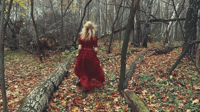Young pretty woman is running in the forest road in autumn season.Slow motion.HD