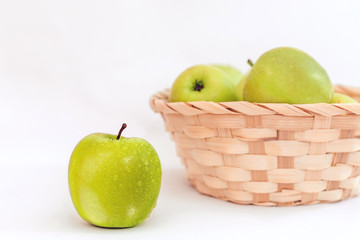 green apples in a basket on a white background, isolated