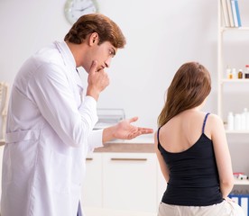 Fototapeta premium Female patient visiting young handsome doctor chiropractor