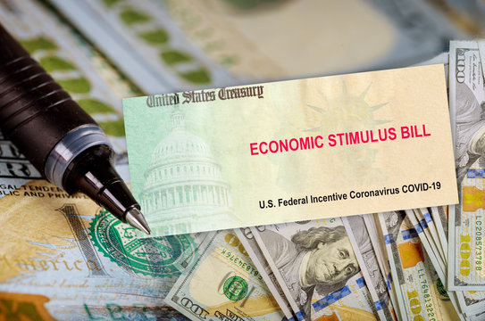 U.S. Economic STIMULUS RELIEF PROGRAM Bill Coronavirus Financial Relief Checks From Government USA Dollar Cash Banknote On American Flag Global Pandemic Covid 19 Lockdown