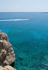 View from the cliff on a motor boat on blue sea water