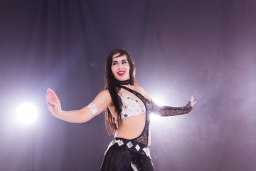 Girl dancing belly dance, fusion or tribal. A woman in a beautiful costume demonstrates charming and gentle movements in the dance.