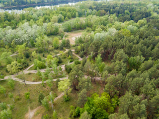 Fototapeta na wymiar Dirt road in the spring forest. Aerial drone view.
