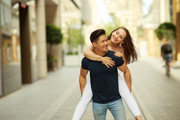 young man carrying his girlfriend on his back.