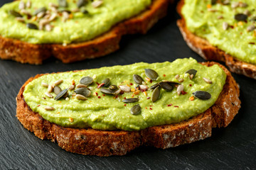 Healthy Homemade Avocado creamy Toast with nuts mix on rustic stone board