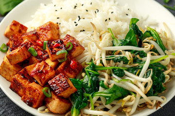 Fried Asian tofu in sweet chilli glaze served with rice, steamed spinach and beansprouts. Vegetable healthy food