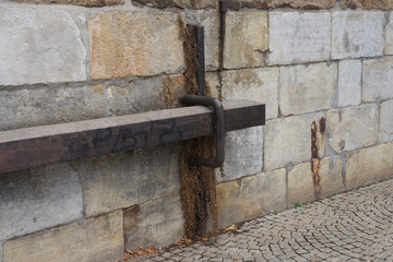 Alte mehrfarbige Natursteinwand mit metallischem Riegel