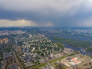 Spring rain over Kiev. There are black thunderclouds in the sky, dark rain falls on the city. Aerial drone view.