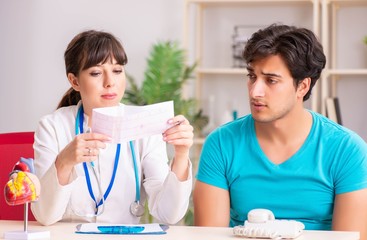 Young man visiting female doctor cardiologist