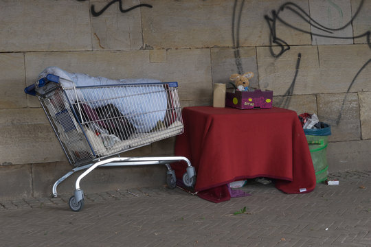 Im Einkaufswagen zusammengetragene Besitztümer eines Obdachlosen auf der Strasse unter einer Brücke
