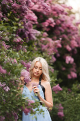 Beautiful adult woman in a flowering lilac