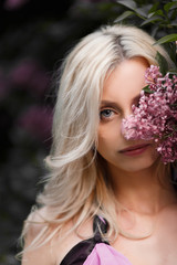 Beautiful adult woman in a flowering lilac