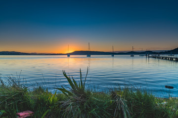 Fototapeta na wymiar Sunrise, boats and a clear sky over the Bay