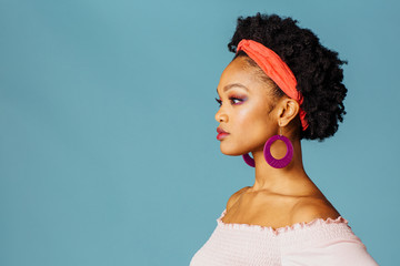 Profile portrait of a young woman in thinking looking off camera, isolated on blue color background © Carlos David