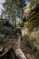 Fototapeta na wymiar Stolowe Mountains National Park. Wooden boardwalk in Rock Labyrinth hiking trail Bledne Skaly near Kudowa-Zdroj, Lower Silesia, Poland.