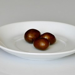 Semi dei frutti del nespolo nel piattino bianco. Preparazione del liquore amaro