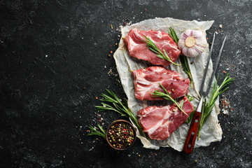 Raw meat steaks with rosemary and spices. Top view. Free space for your text.