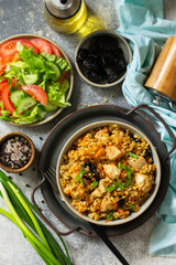 Bulgur pilaf. Healthy eating concept. Bulgur with chicken, vegetables and prunes on a gray stone or slate countertop. Top view flat lay background.