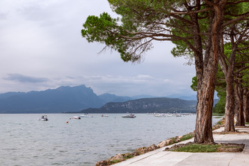 Fototapeta na wymiar View of Lake Garda from the promenade between town Lazise and Bardolino.