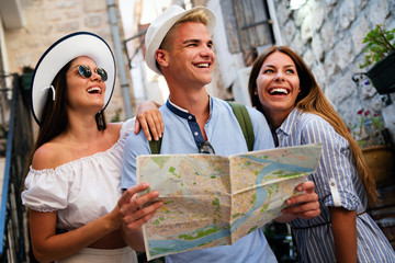 Happy traveling tourists sightseeing with map in hand