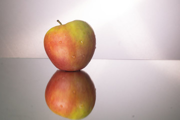 Red apple on mirroring table. Gorizontal image with copy space.