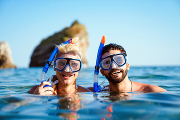 Happy friends men enjoying summer vacation and scuba diving