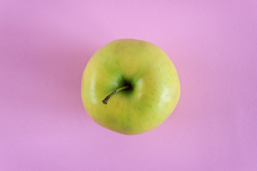 Top view of green apple isolated on pink background. Close up golden apple. Healthy fresh food concept.