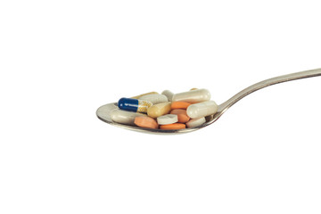 pills on a white background in spoon 