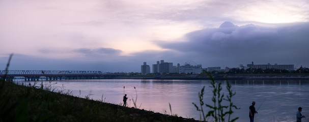 View of people fishing during panoramic sunset at Kyuedogawa River in Maihama, Urayasu.