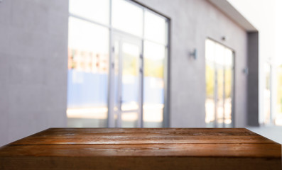 wooden table on a blurred background of windows of the windows of the columns of a street cafe, bar, restaurant.