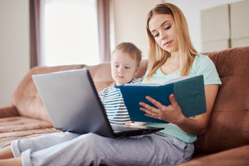 Mom with notepad and laptop studying with her toddler
